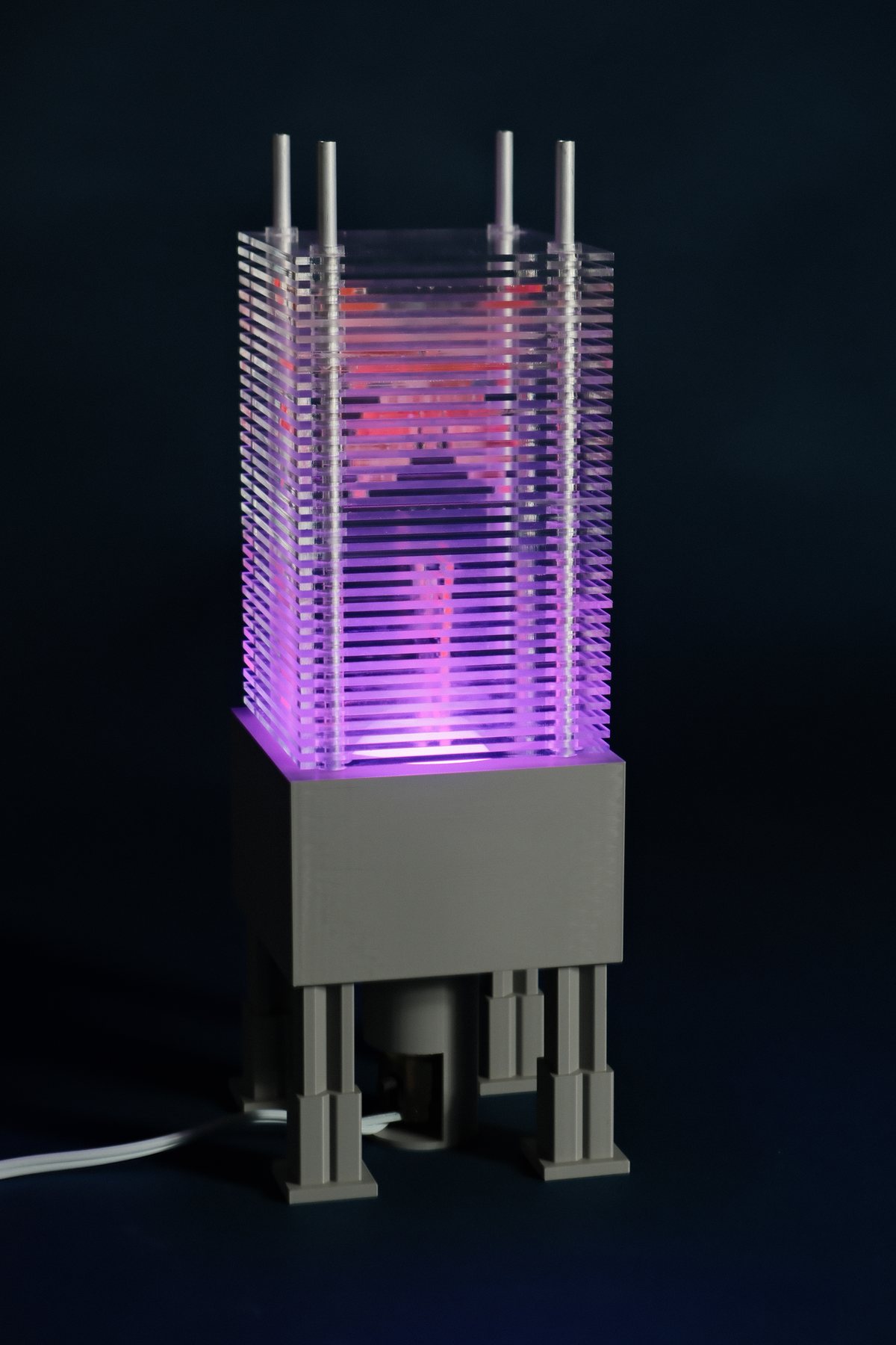 Interchangeable Patterned Lamp glowing pink through colored acrylic pattern slices