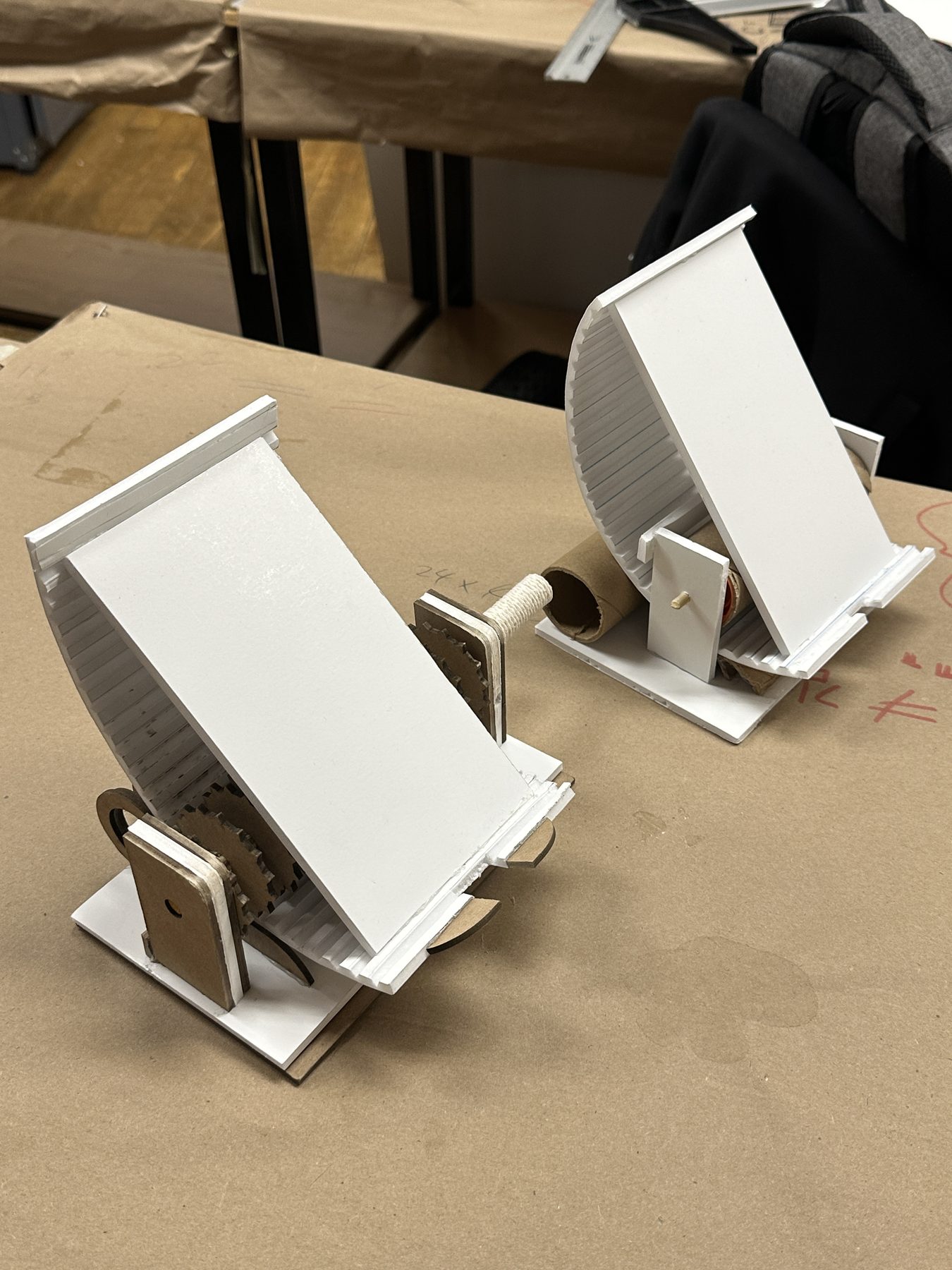 Two early white physical prototypes of the phone stand
