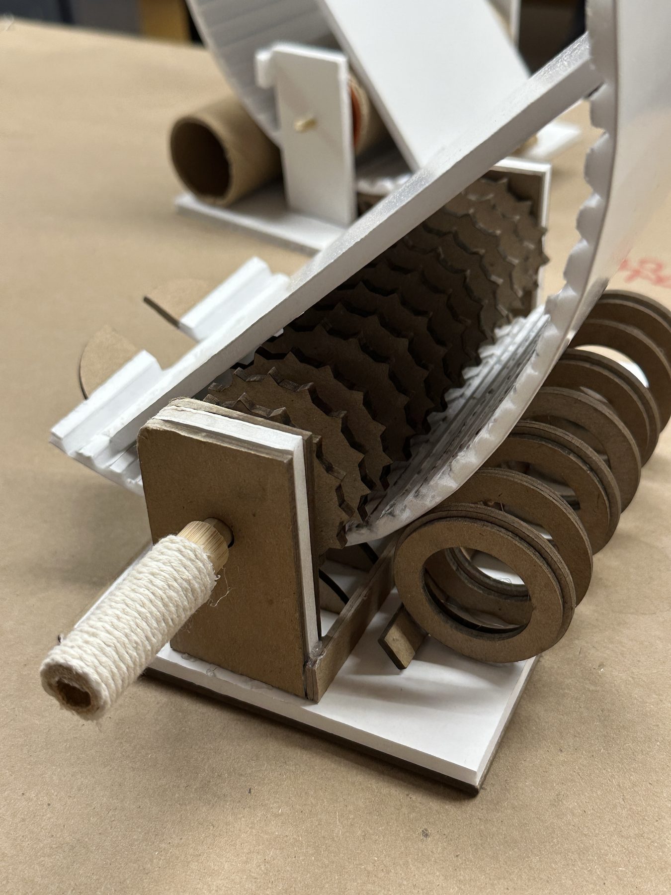 Cardboard and foam-board prototype exposing the toothed mechanism